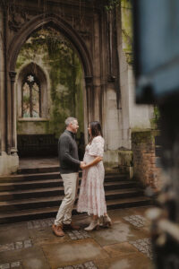 Maternity Photoshoot in St Dunstan in the East Church. Man and Woman standing and holding hands in the ruins.